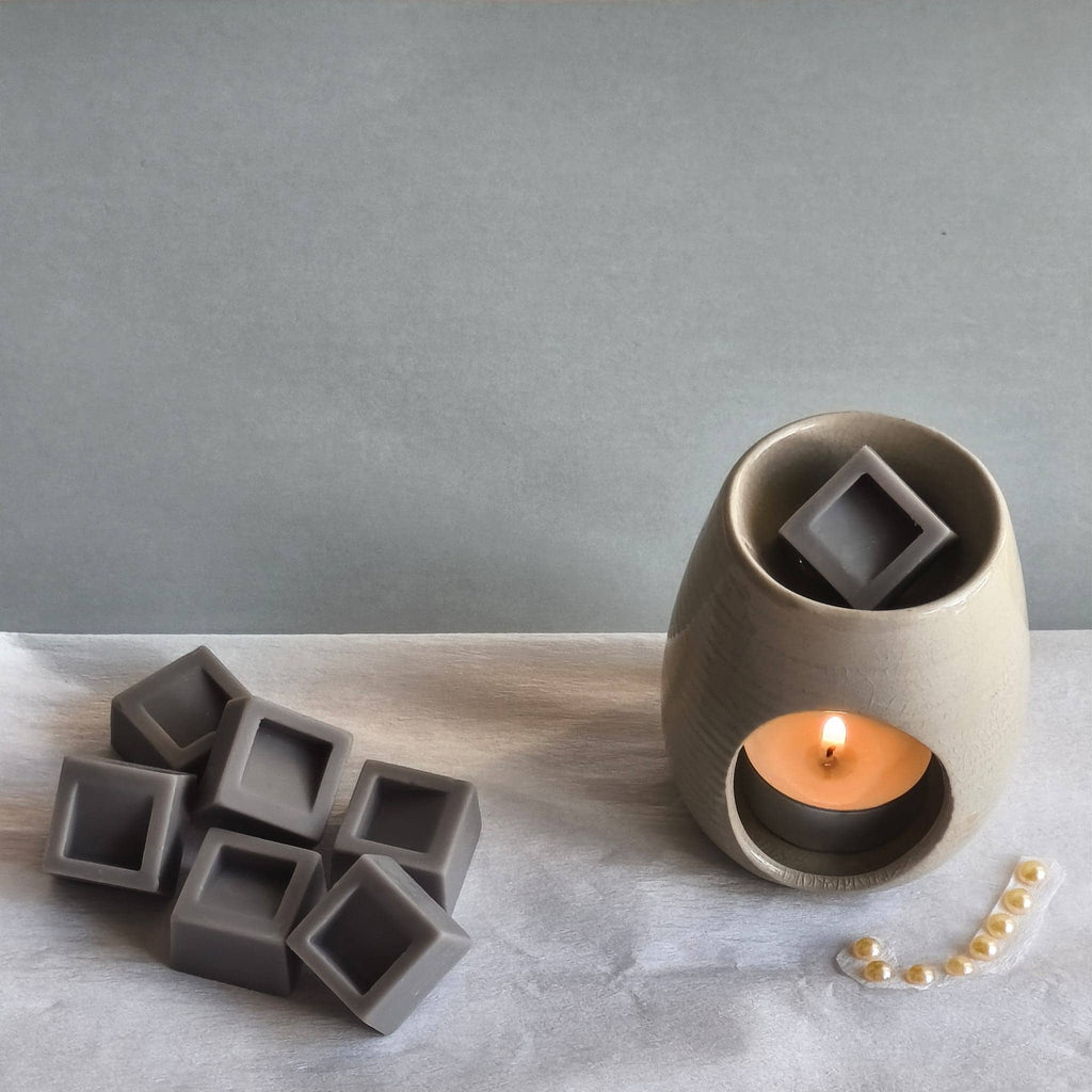 Wax melts con forma de cubos derritiéndose en quemador aromático
