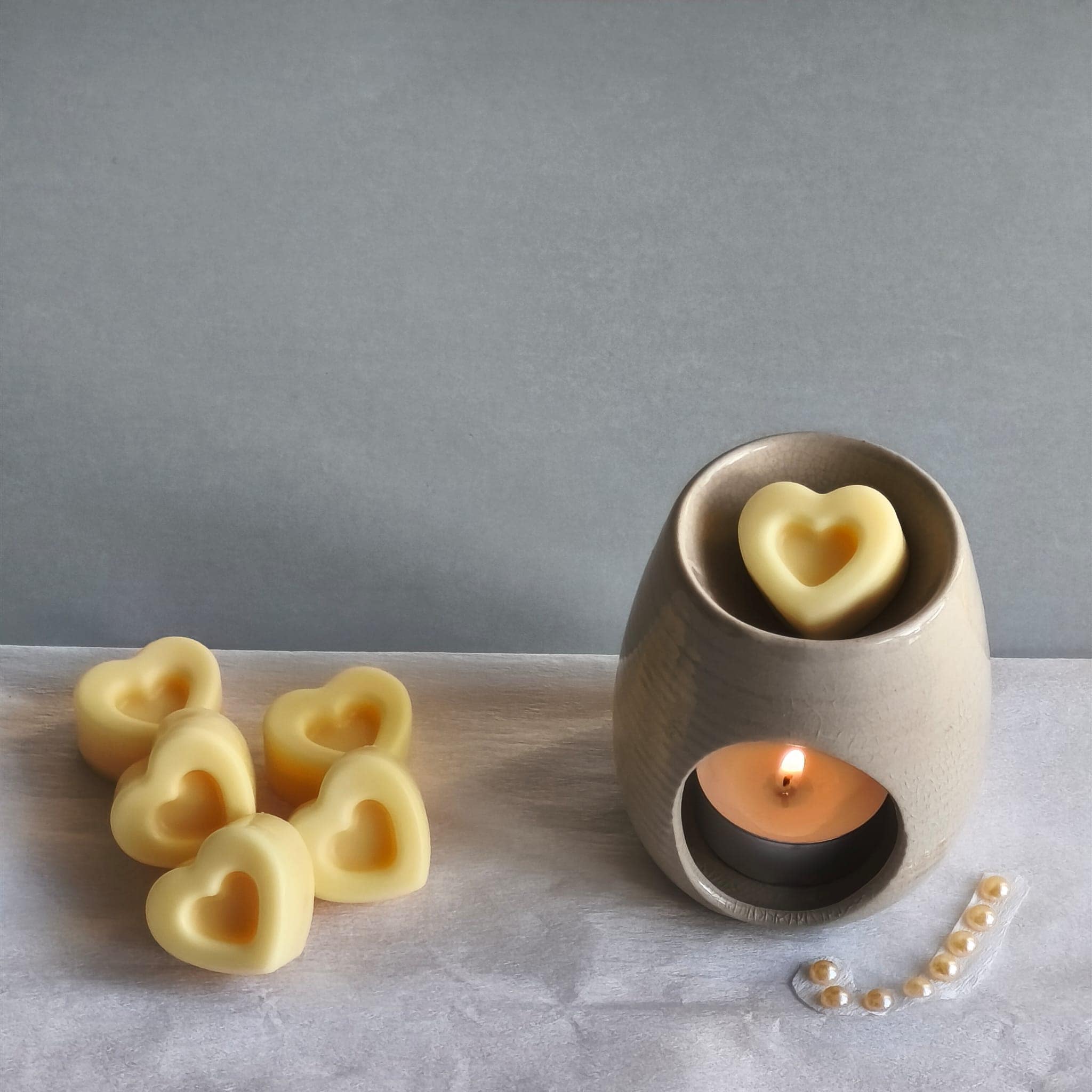 Wax melts con forma de corazones derritiéndose en quemador aromático
