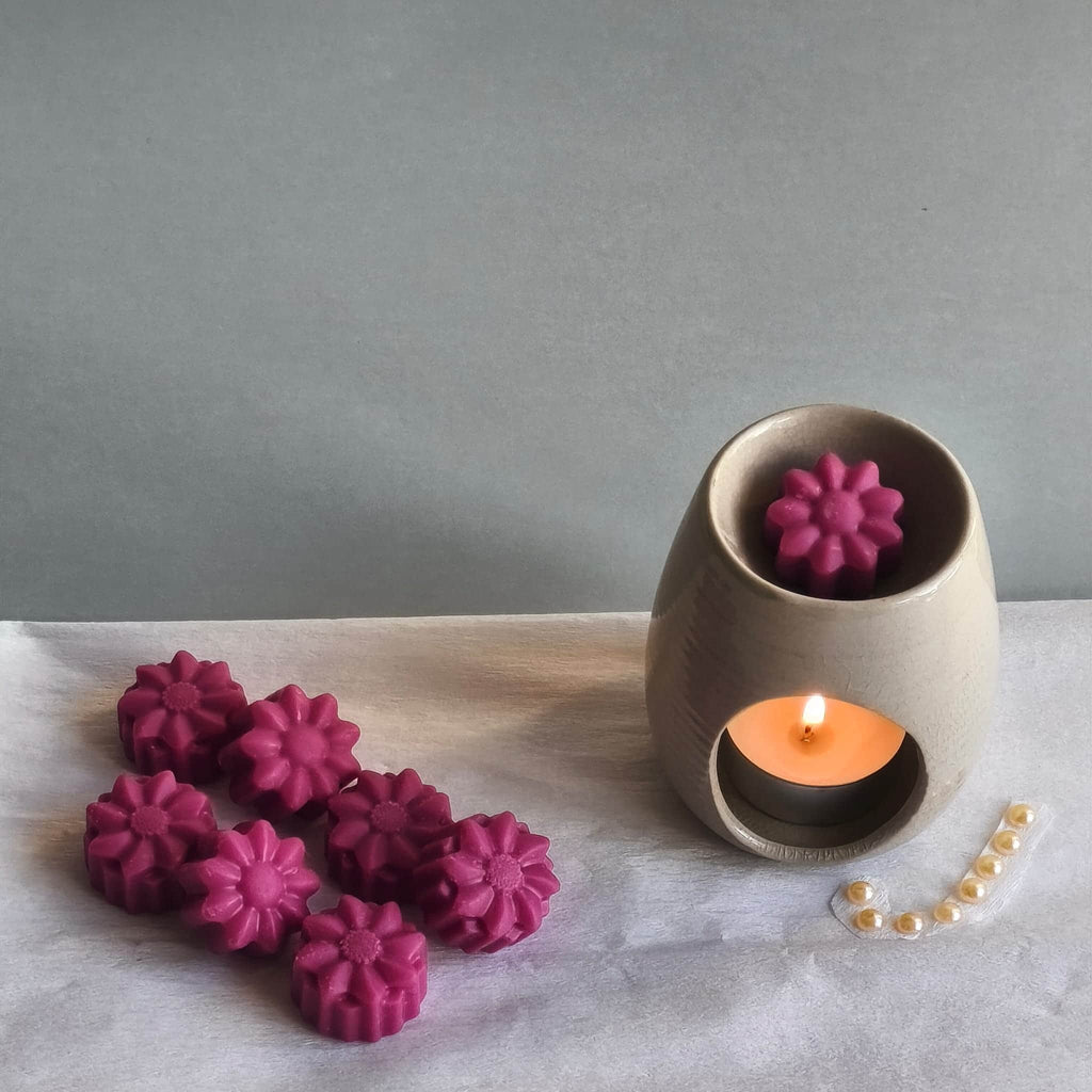 Wax melts con forma de flores derritiéndose en quemador aromático
