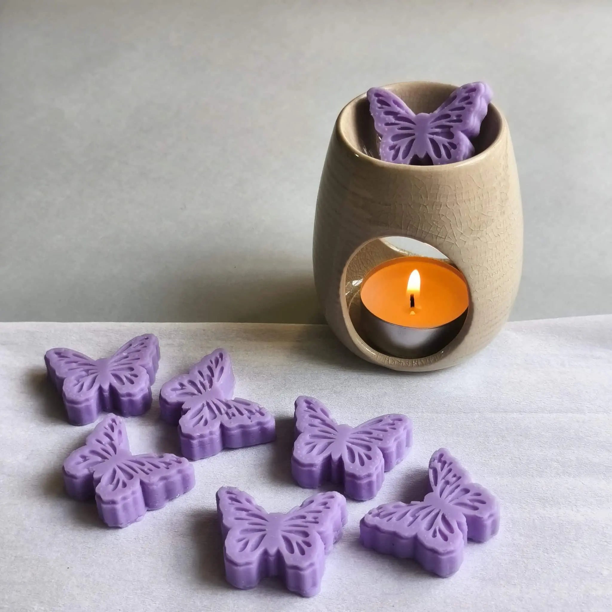 wax melt con forma de mariposasobre quemador