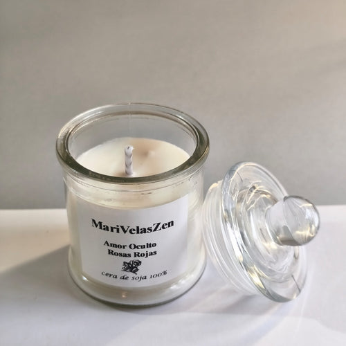 Vela artesanal Amor Oculto en tarro de cristal con tapa abierta, cera de soja 100% natural, aroma rosas rojas, etiqueta MariVelasZen, hecha a mano en España