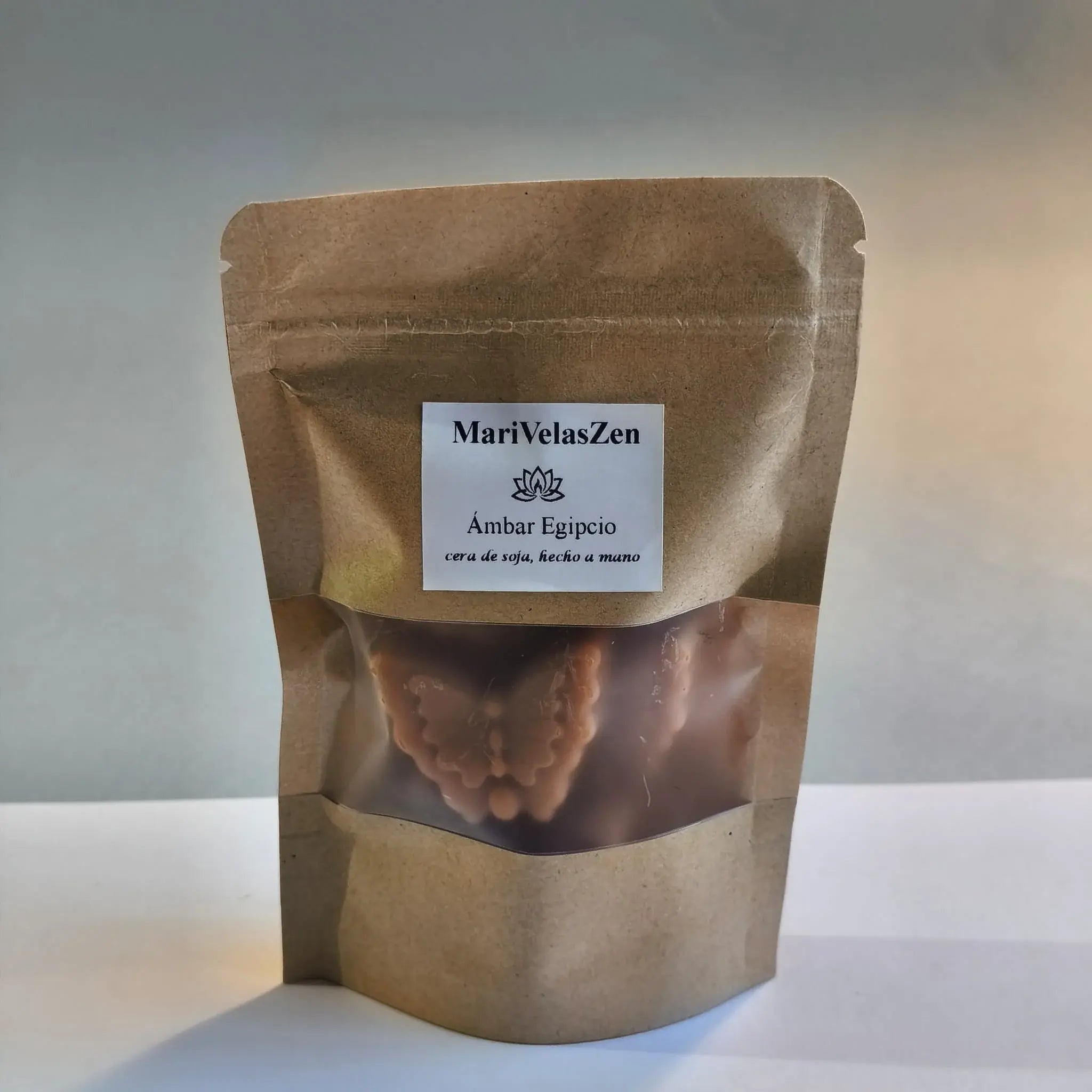 Bolsa kraft con wax melts artesanales MariVelasZen aroma Ámbar Egipcio, cera de soja hecho a mano, sobre mesa de madera con luz natural